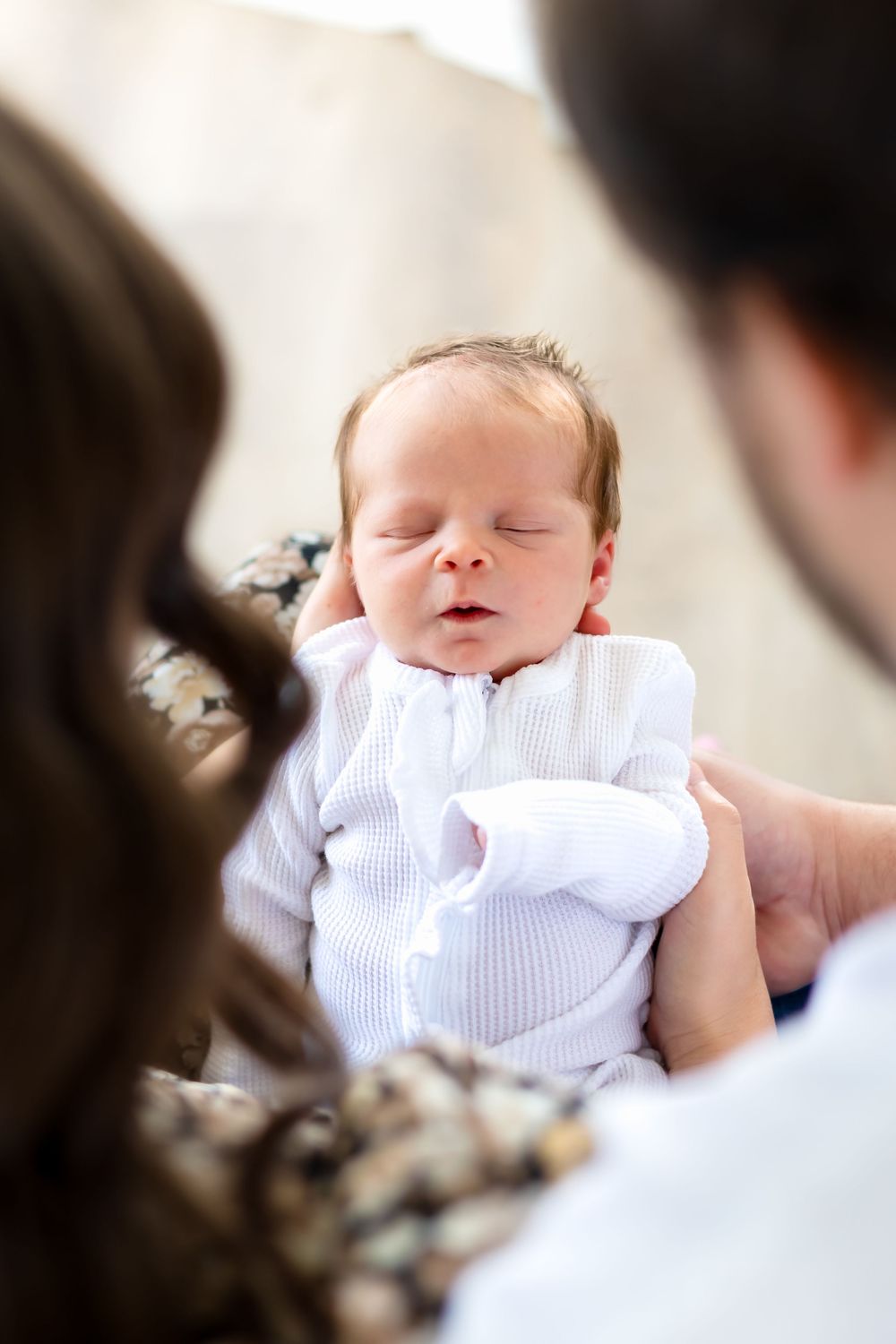 Close-up of newborn baby girl sleeping peacefully wrapped in white swaddle during Prospect Farms photo session near Athens, GA