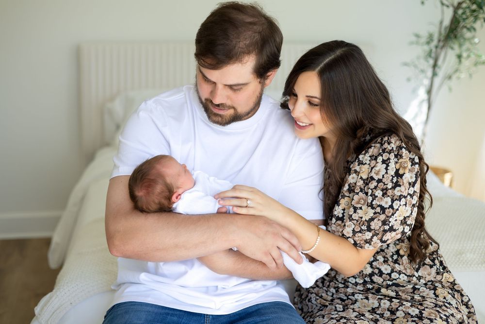 Mom and dad holding newborn baby girl together during lifestyle photography session at Prospect Farms in Athens, GA