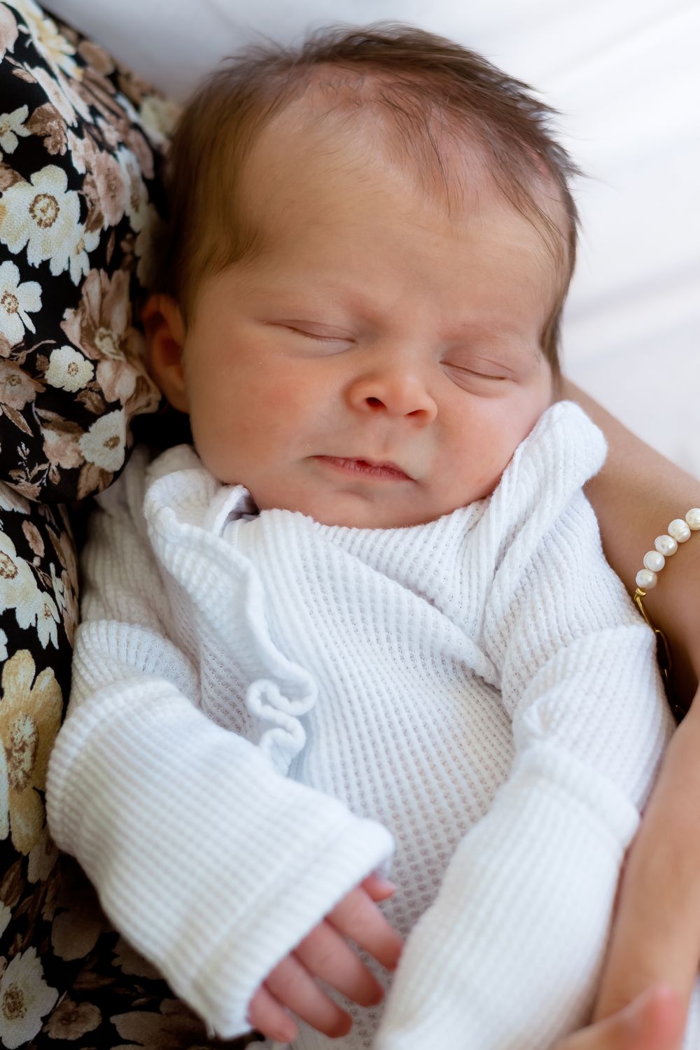 Close-up of newborn baby girl sleeping peacefully wrapped in white swaddle during Prospect Farms session near Athens, GA
