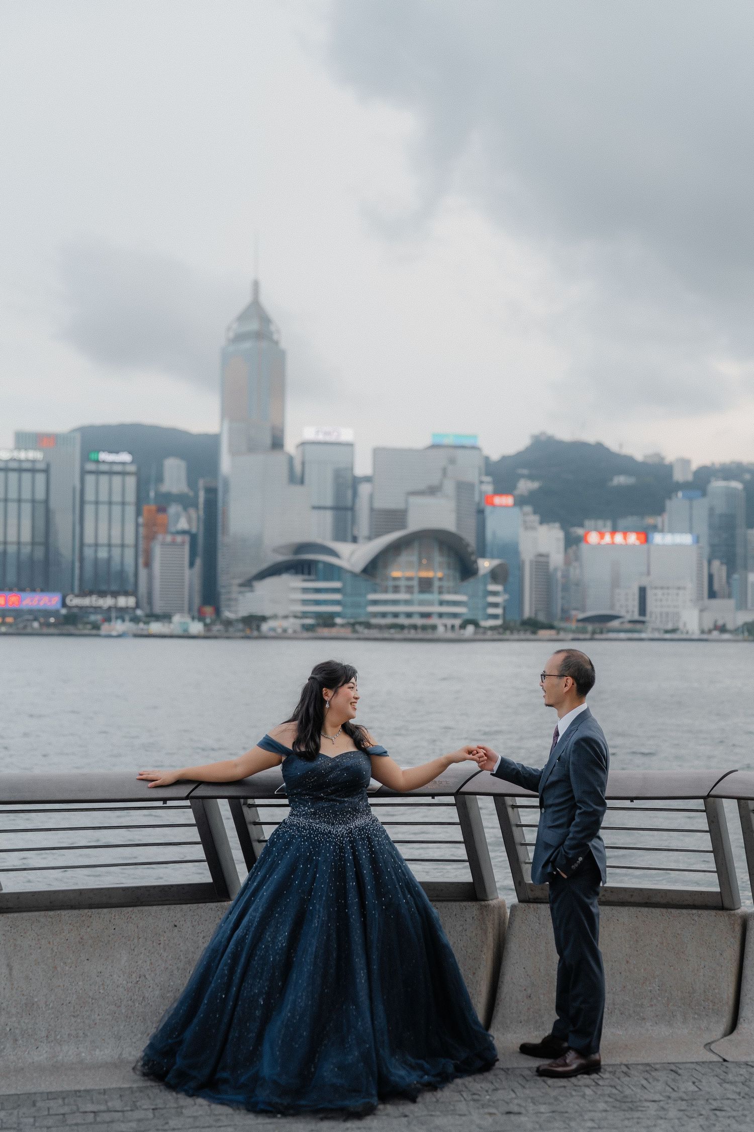 A playful photo sequence of a couple posing by Victoria Harbor in Hong Kong.