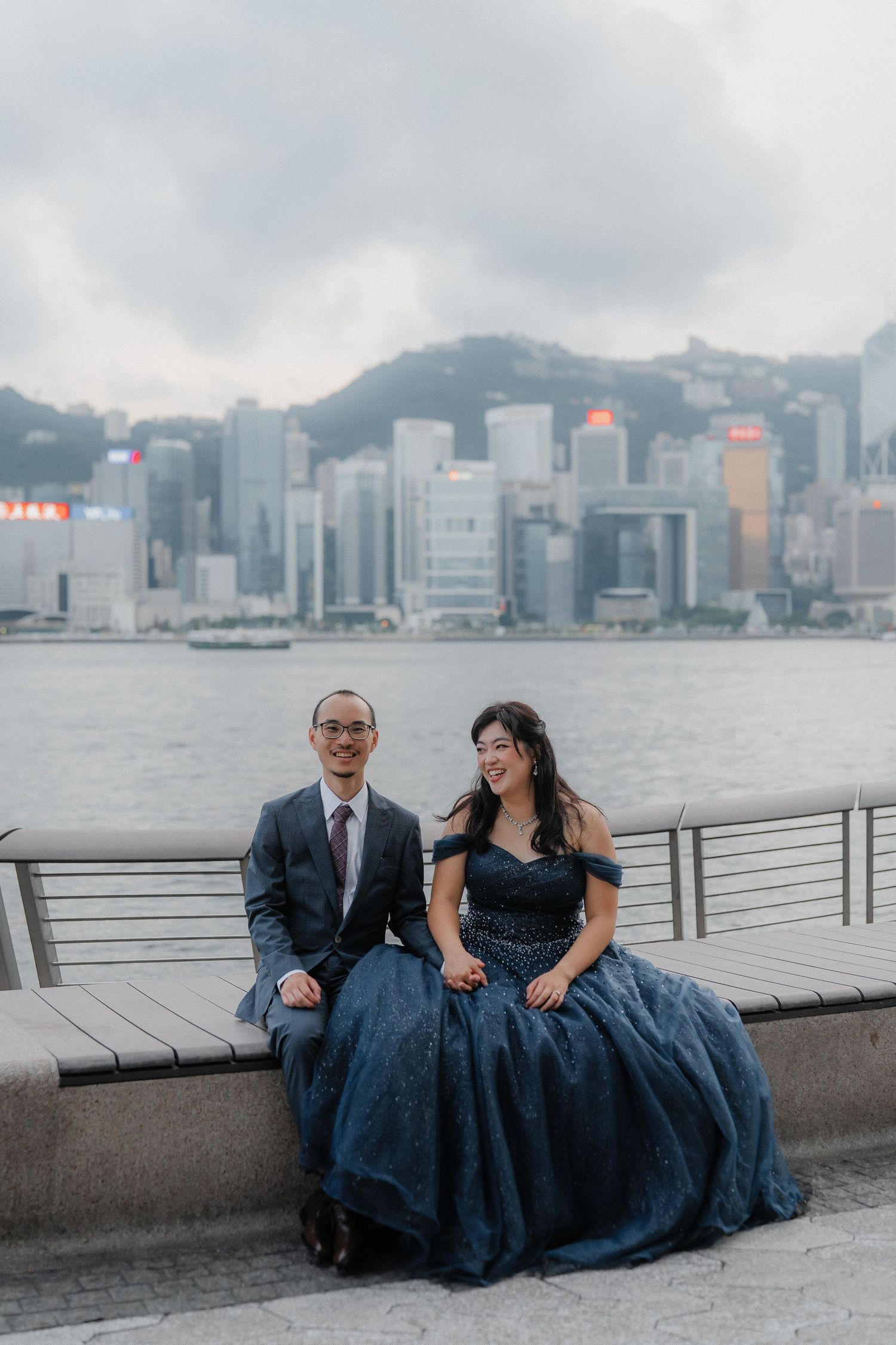 A couple shares laughs while posing casually along Hong Kong's Victoria Harbour.