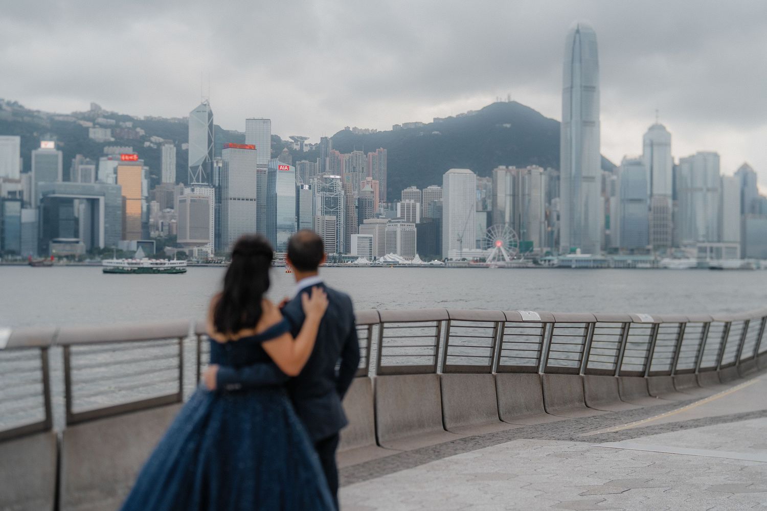 A cloudy view of Hong Kong's iconic skyline from Victoria Harbour showcases towering skyscrapers and urban architecture.