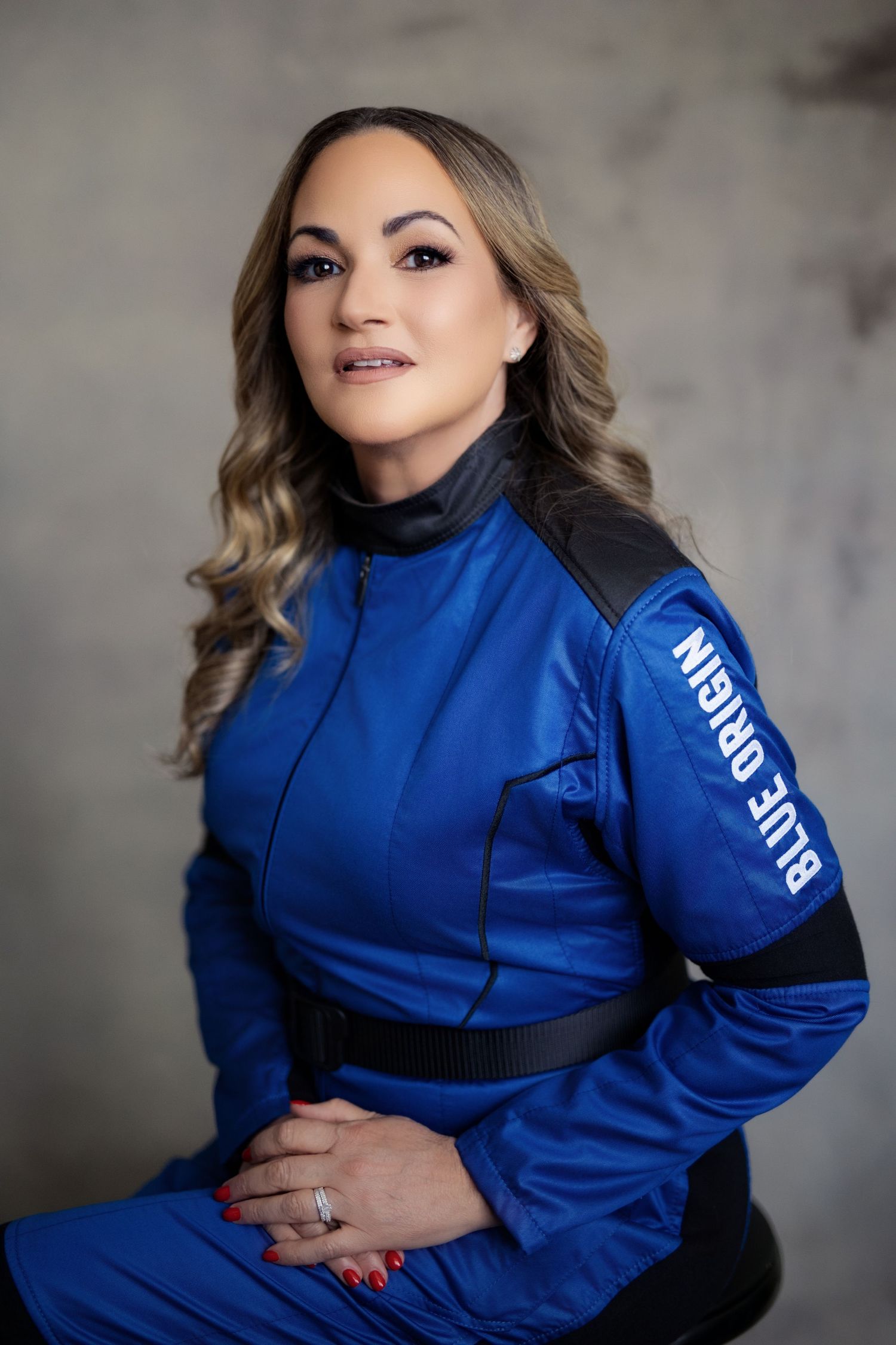 Professional fashion photography series showing a blue zip-up jacket styled against a gray studio background.