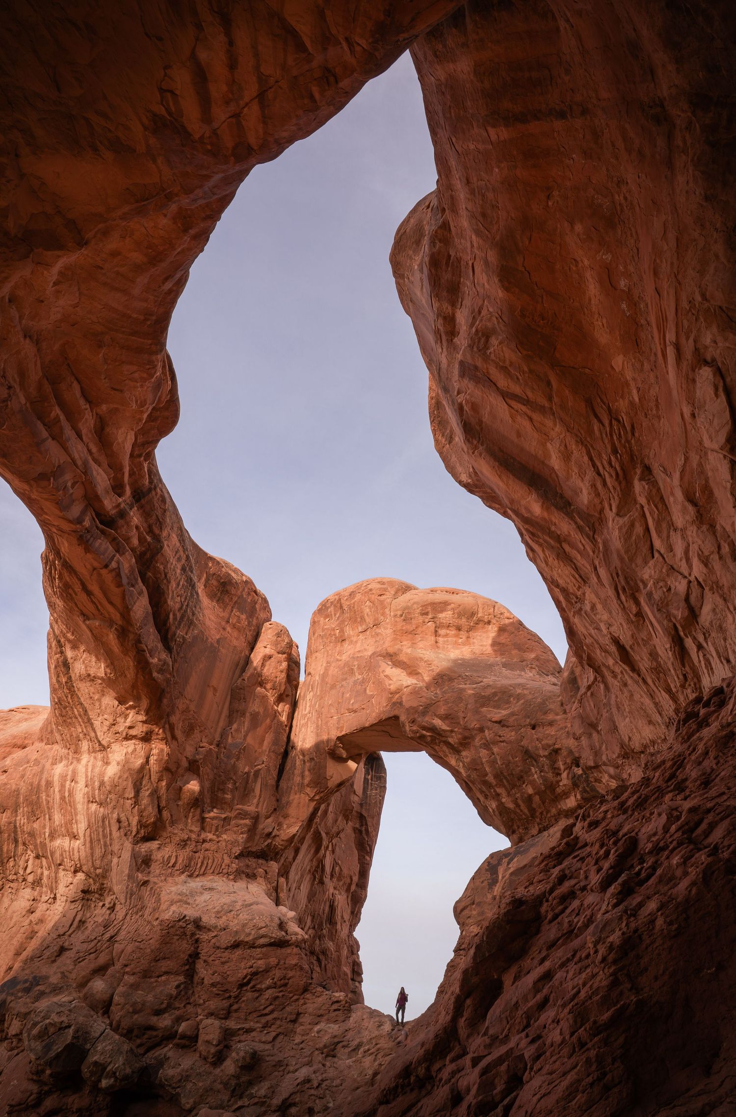Dramatic red rock formations and cliffs under stormy skies at Capitol Reef National Park in Utah's desert landscape.