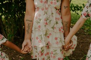 Floral print dress details shown against green outdoor backdrop.