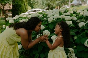 Candid moments of children playing with flowers in a sunny garden.