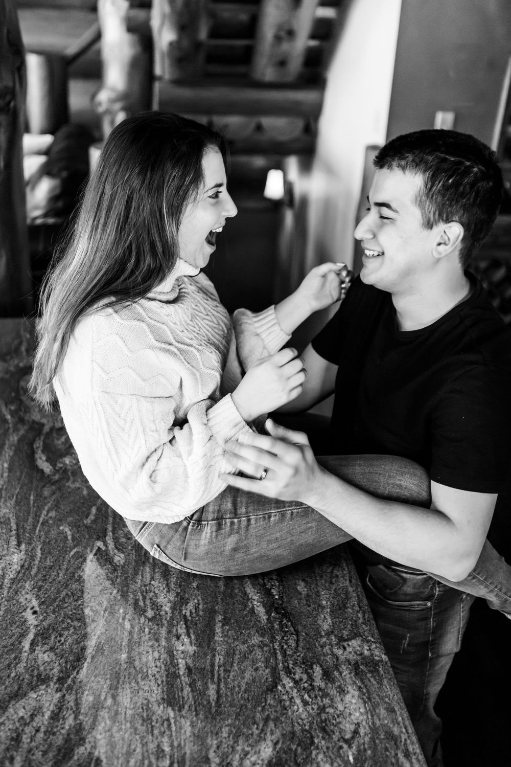 A couple shares intimate moments in a black and white photo series showing playful interaction and embraces.