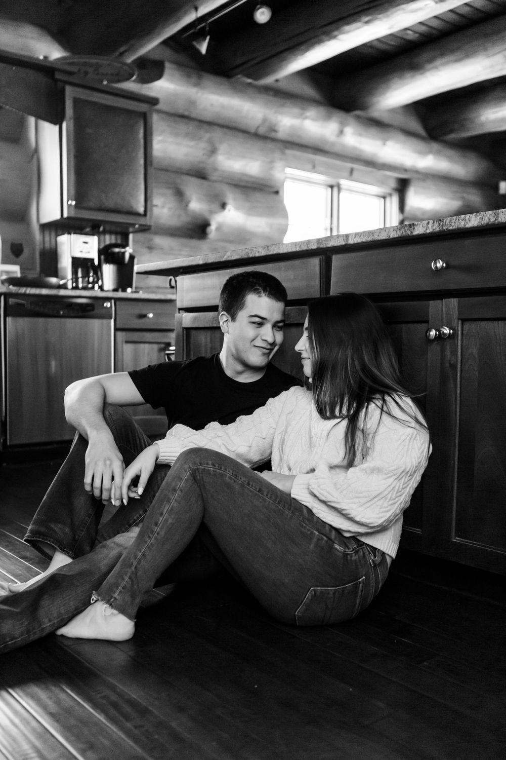 A person casually lies across four wooden bar stools in black and white progression photography.