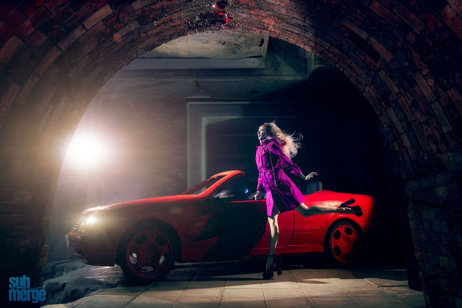 Dramatic photoshoot of red sports cars in dark setting with moody lighting and stylized figure poses.