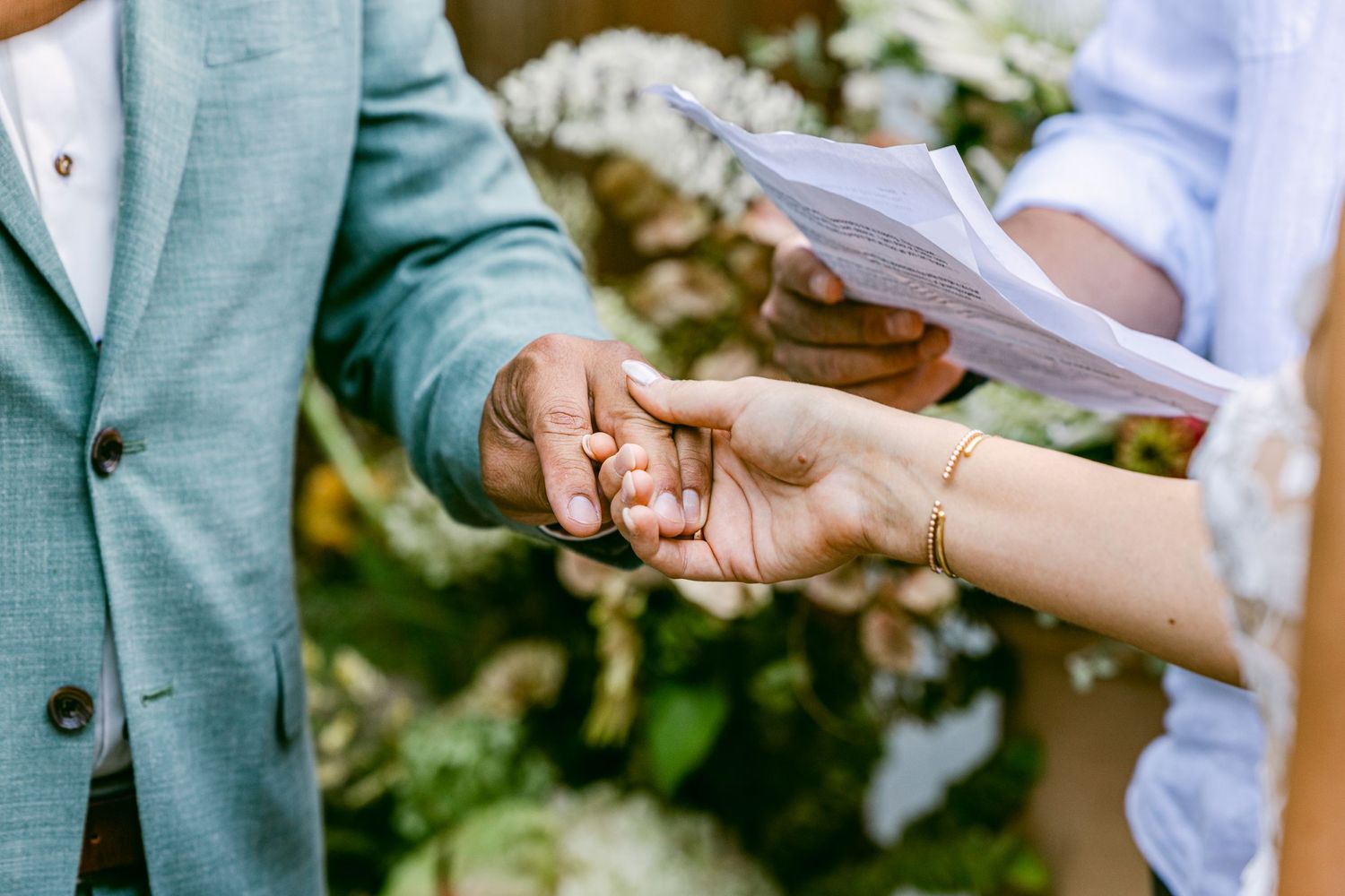 a close up of a bride putting a wedding ring on the grooms finger