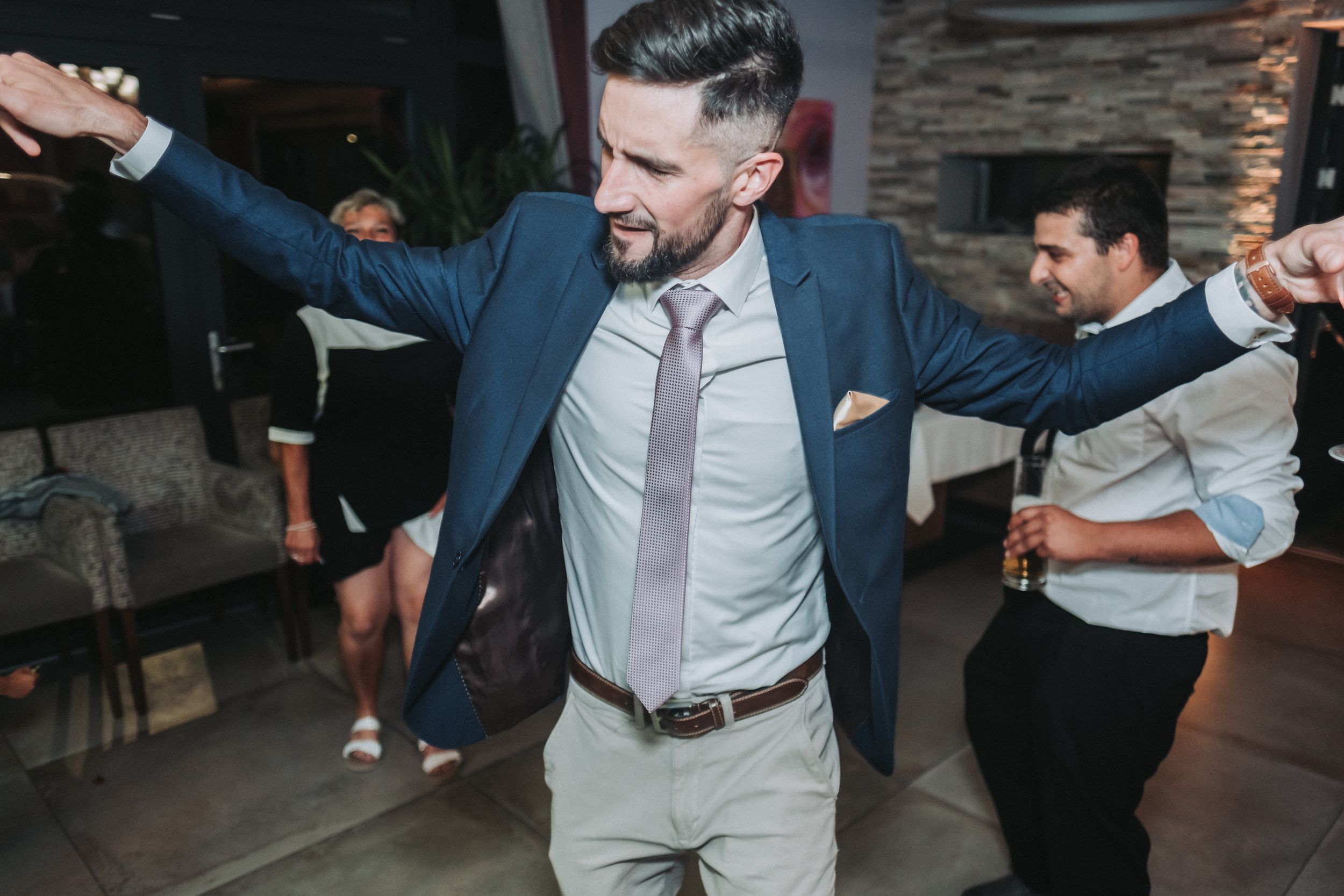 Guest dancing and celebrating at a wedding reception in formal attire.