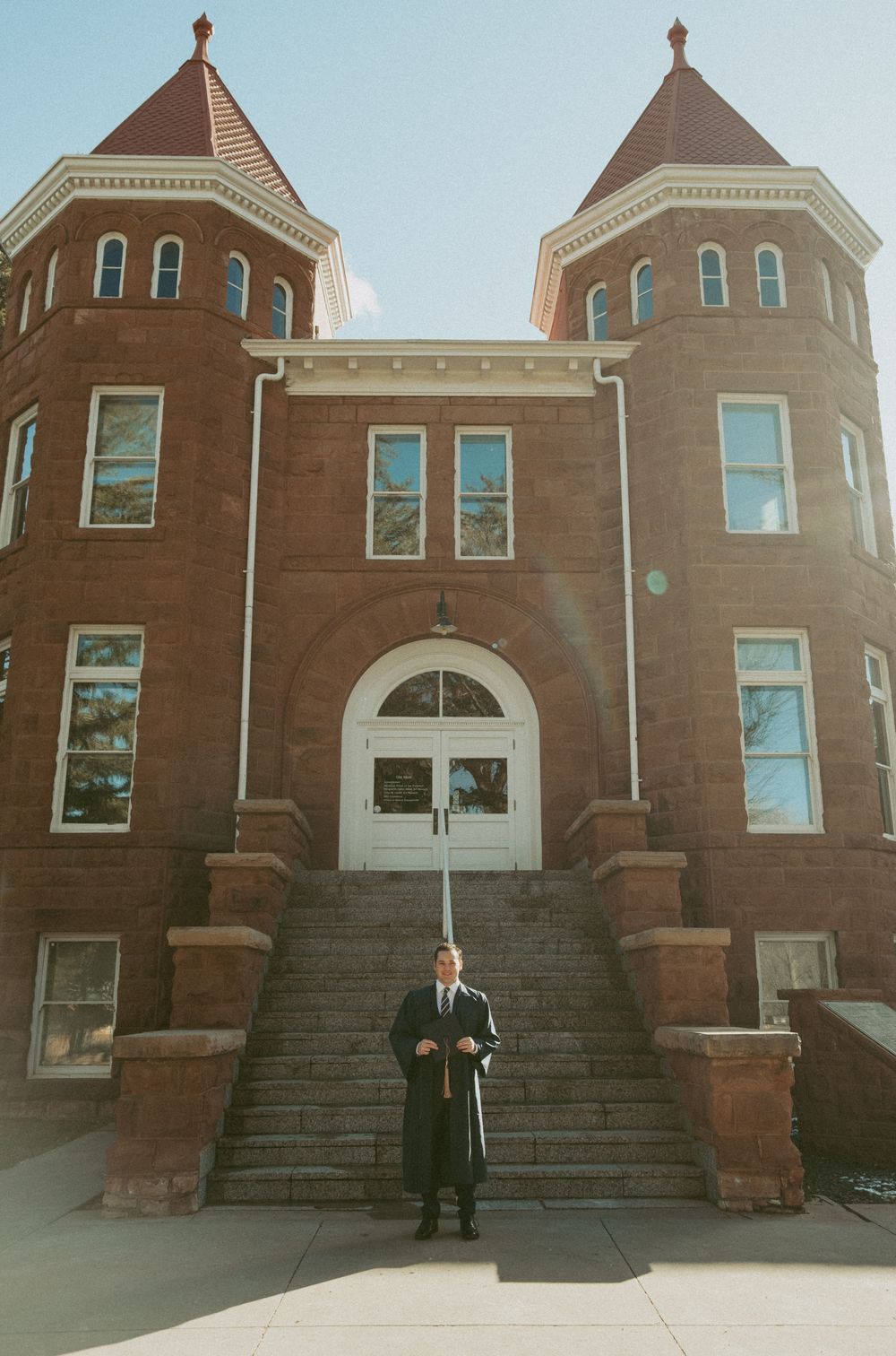 A classic brick church or historic building with twin towers and arched entrance featuring grand stone steps in the foreground.