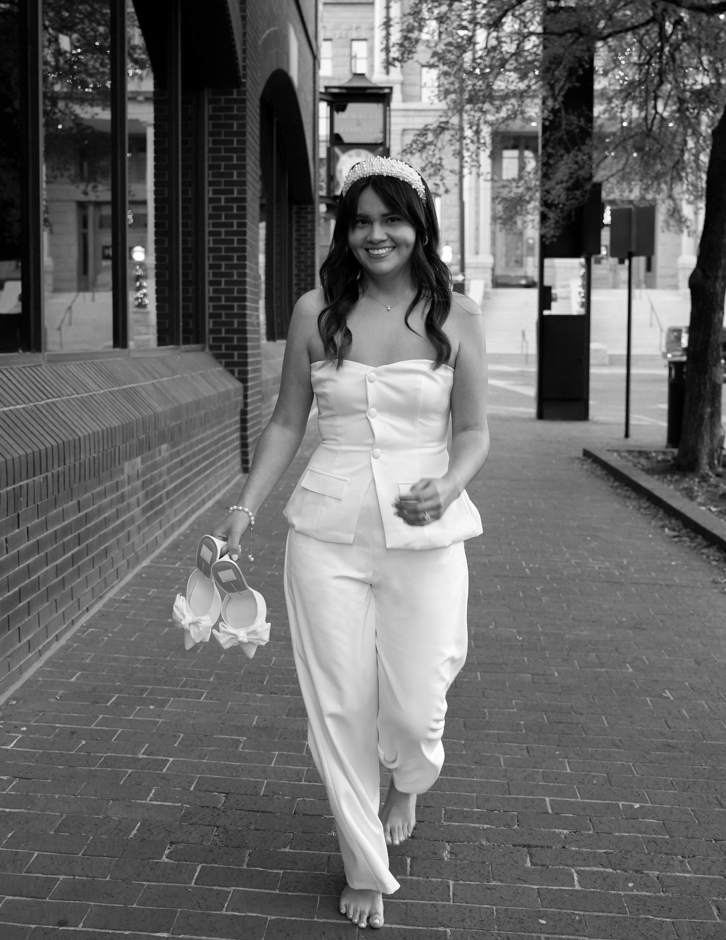 Elegant bride-to-be holding a bouquet while strolling through a cityscape