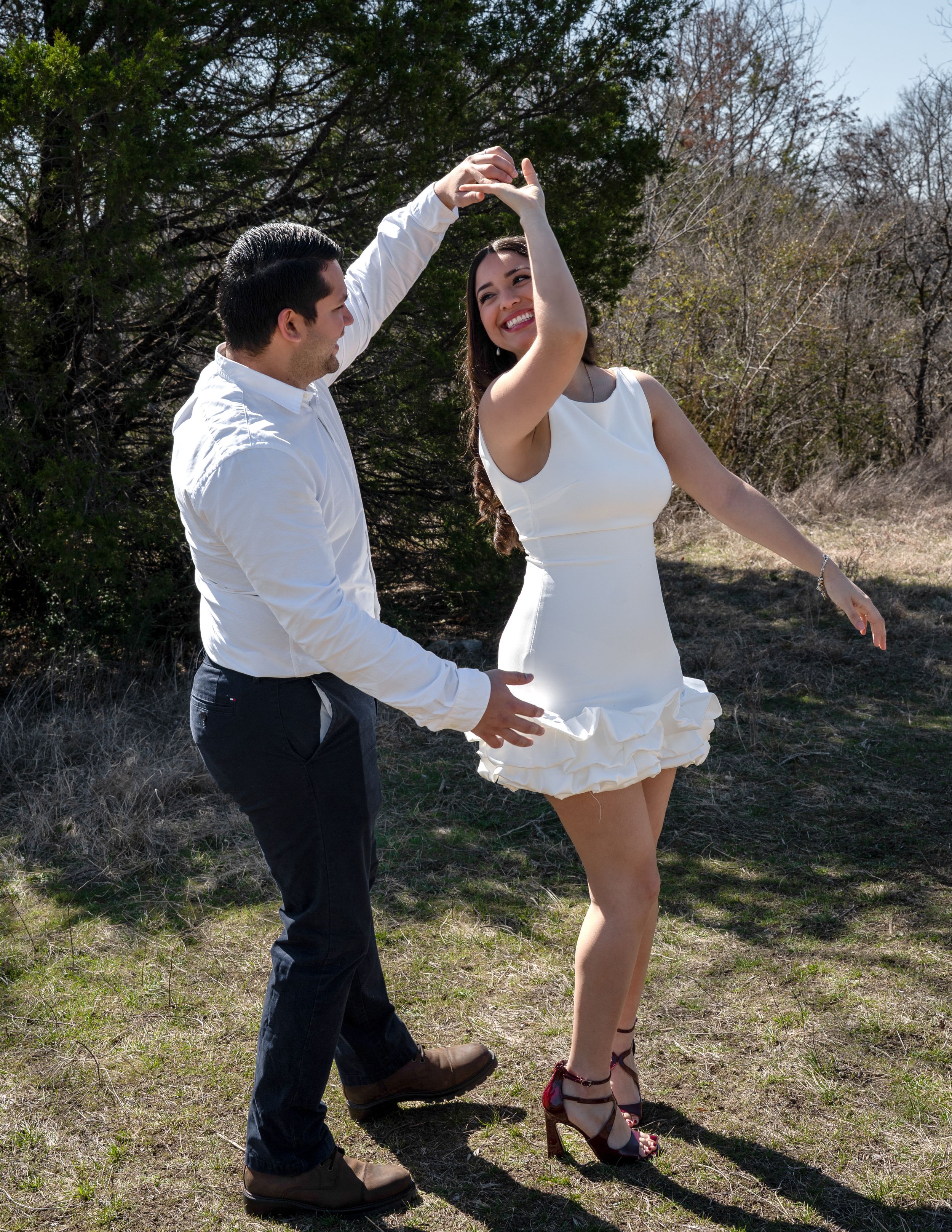 Playful outdoor photo of bride twirling with groom — candid wedding photography in Grapevine, Texas.
