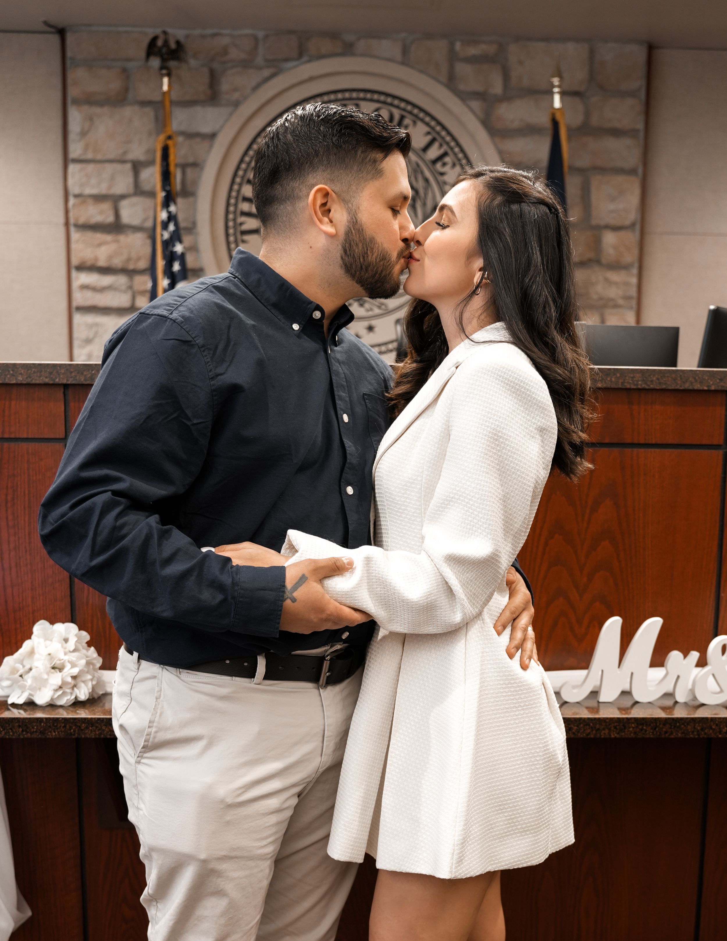 Newlywed couple sharing a warm hug at their courthouse wedding ceremony.