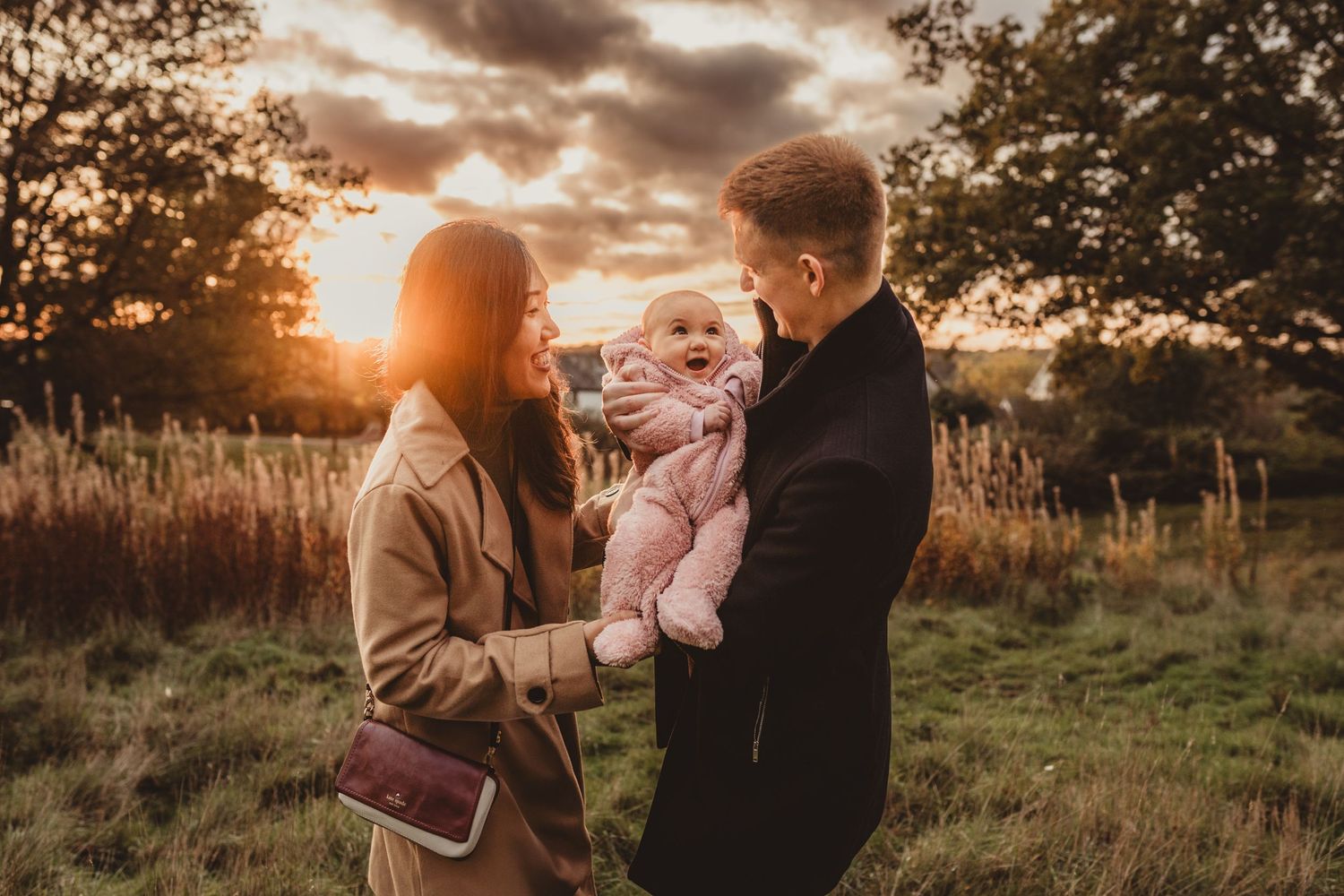 Glowing golden hour family portrait on a heath near Bishops Stortford, Hertfordshire, with the sun setting behind them.