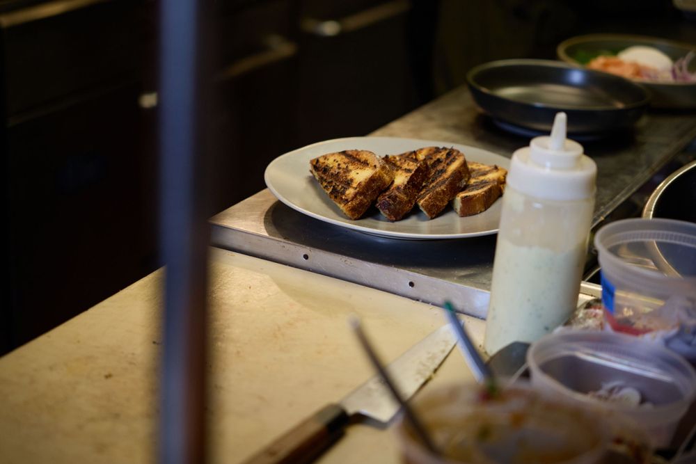 Plated chicken wings with sauce bottle on restaurant counter.