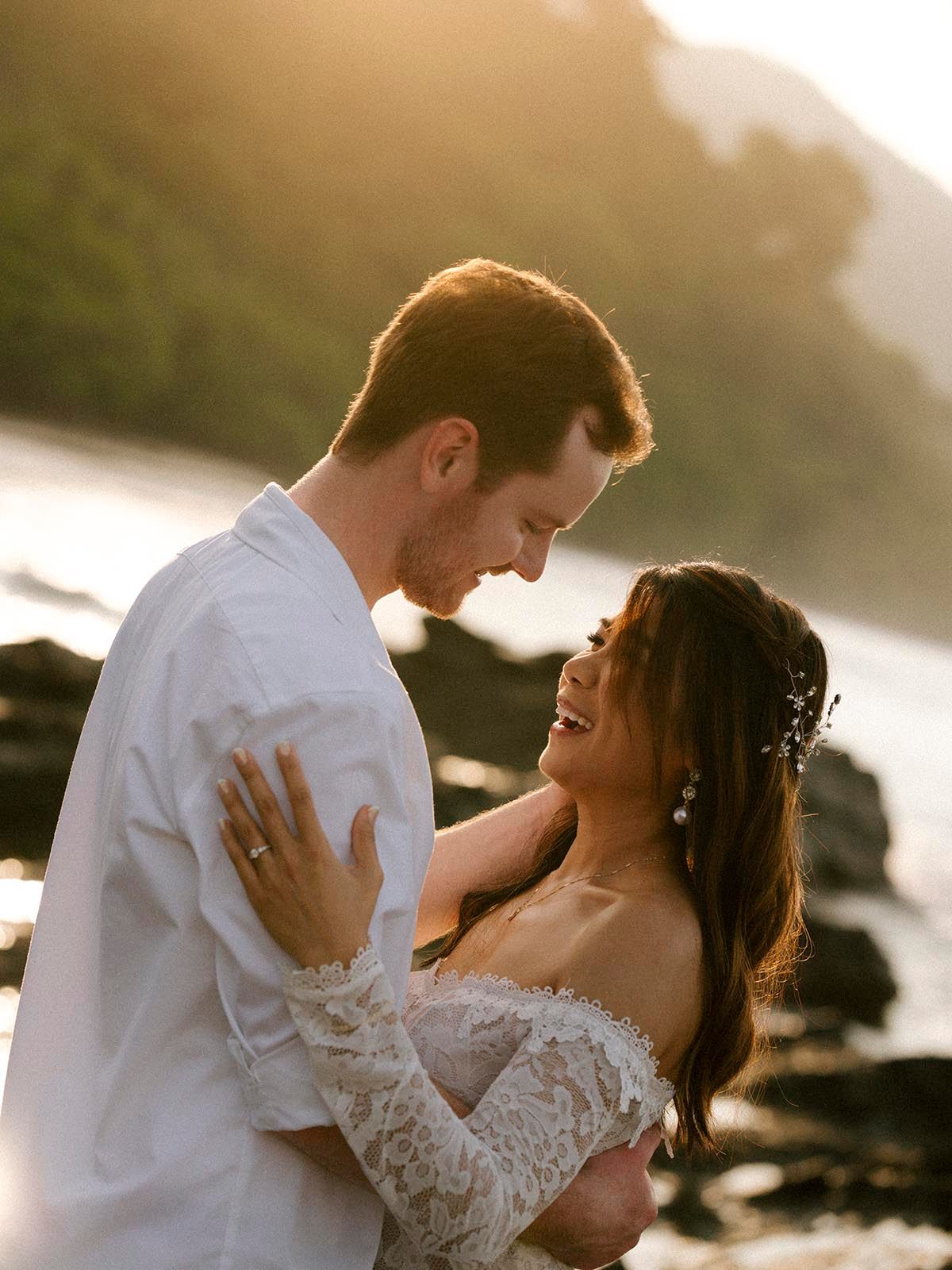 Golden sunrise over palm trees and rocky shore at a Costa Rica elopement.