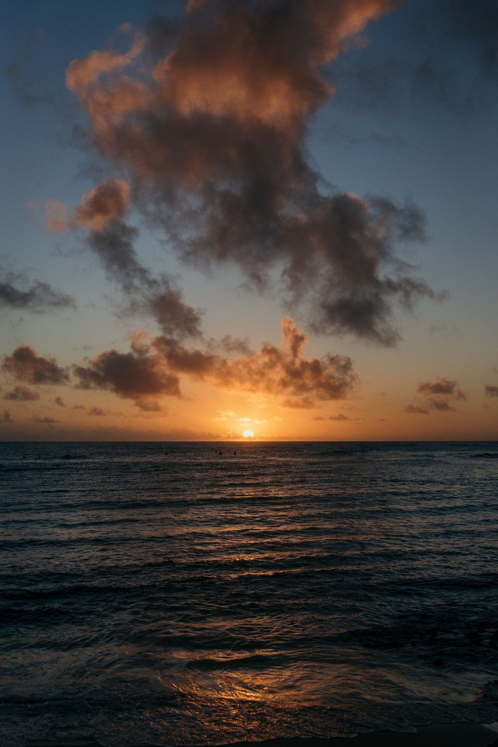 a sunset vibrantly setting into the water in hawaii