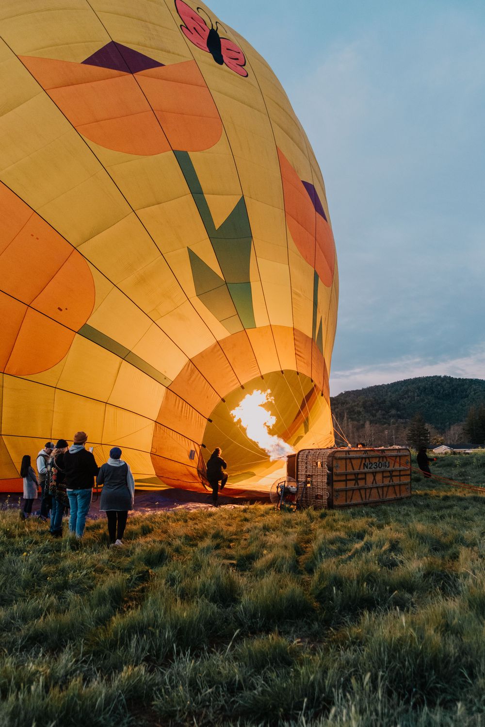 a blue hour photo of fire pushing air into a hot air balloon in Napa California.