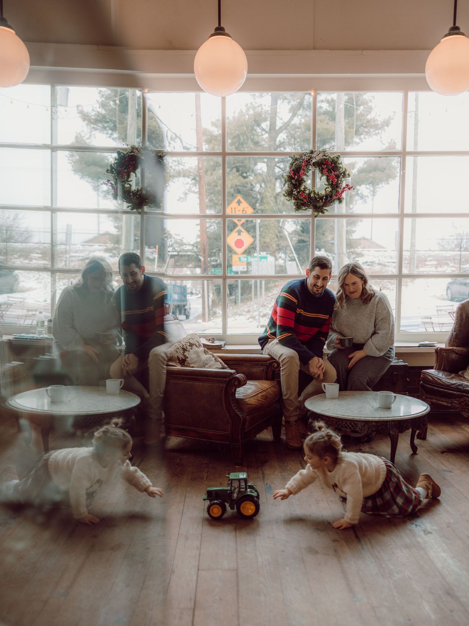 Four progressive frames show people relaxing in a cozy cafe space with pendant lights and large windows.