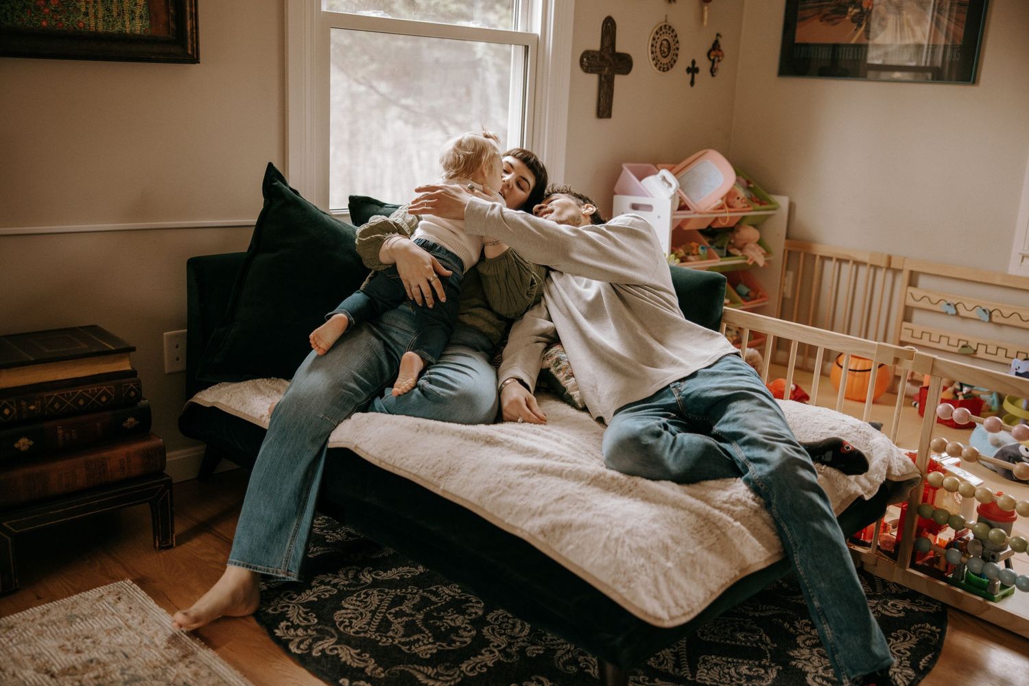 Couple relaxing together on couch in cozy living room with window light and home decor visible.
