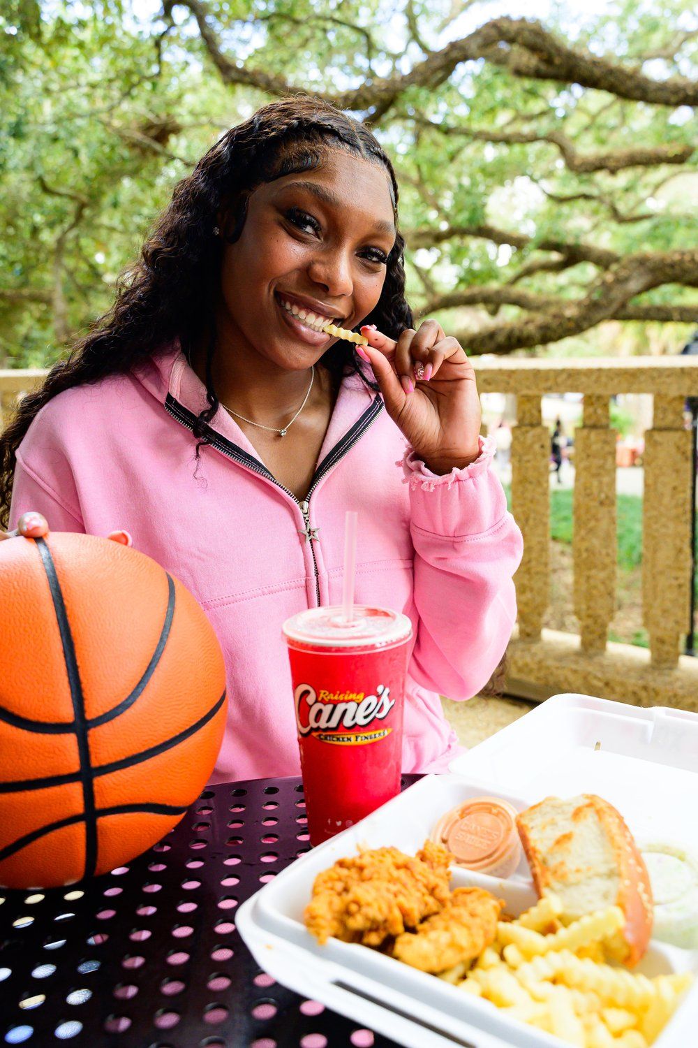 Fast food meal with basketball and drink at outdoor patio table.