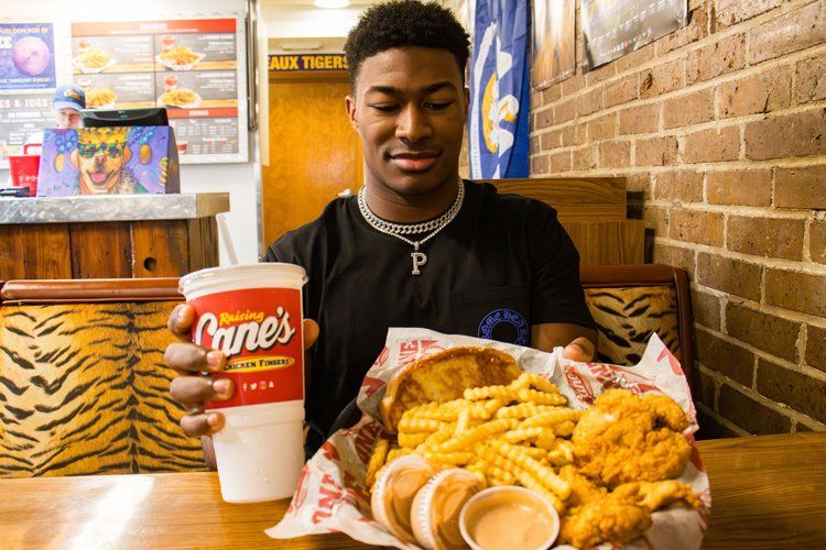 Fast food meal featuring chicken fingers, fries and drink at restaurant table.