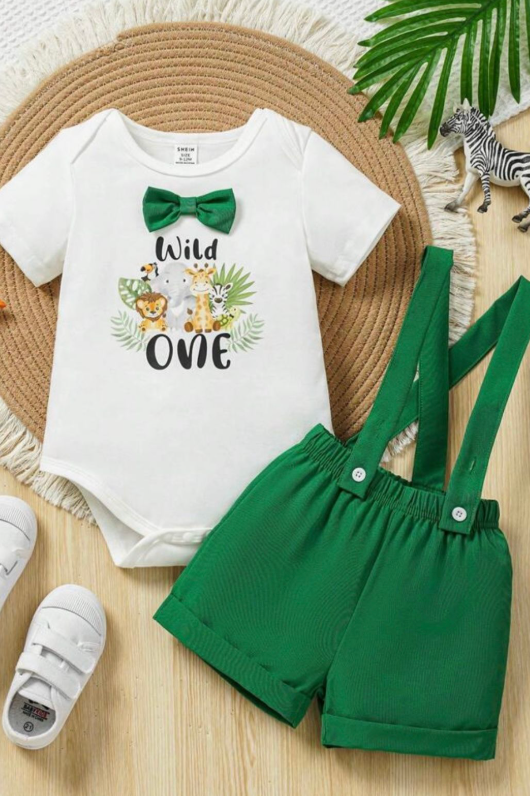 Safari-themed baby outfit set with white onesie and green suspender shorts on natural background.