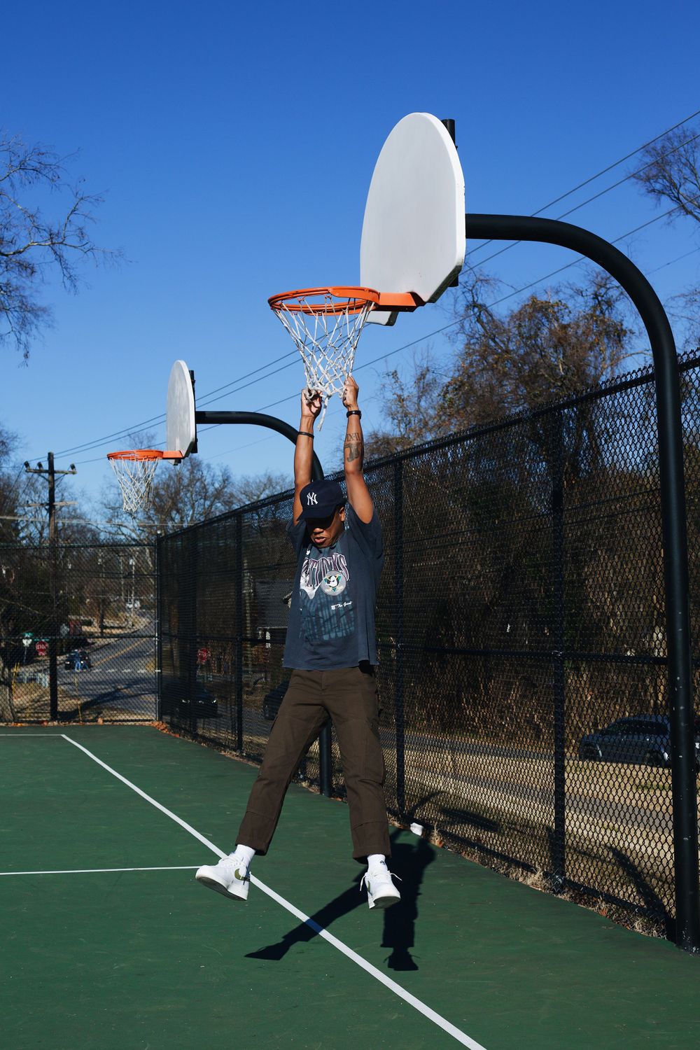 Basketball player jumping to make a shot on outdoor court.