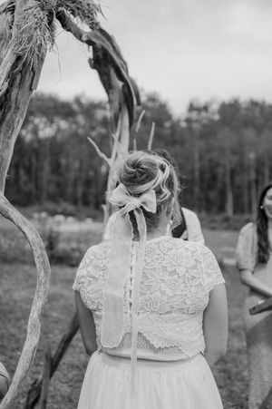 Black and white photos showing details of a white lace wedding dress with cap sleeves in an outdoor setting.
