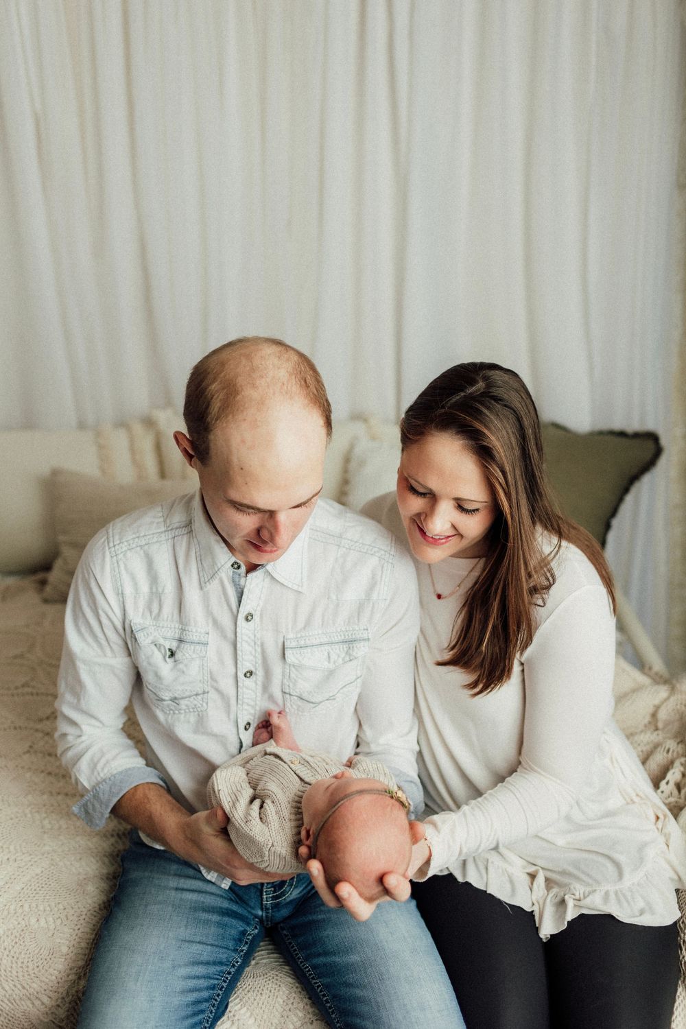 Intimate family moment captured in black and white as parents bond with their newborn.