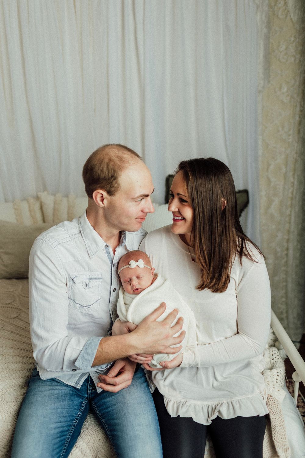 Natural lifestyle family photos showing intimate moments between parents and their newborn.
