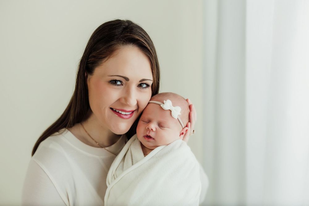 Intimate lifestyle portrait session featuring tender family moments against a bright white backdrop.