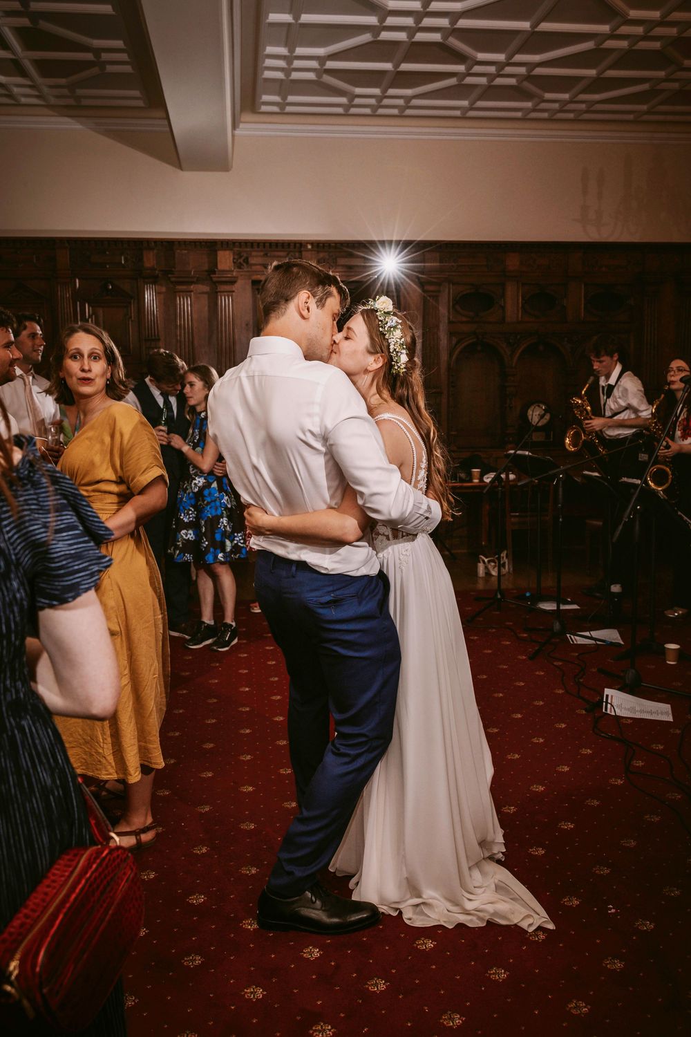 Romantic first dance in an elegant venue with ornate wood paneling and red carpeting.