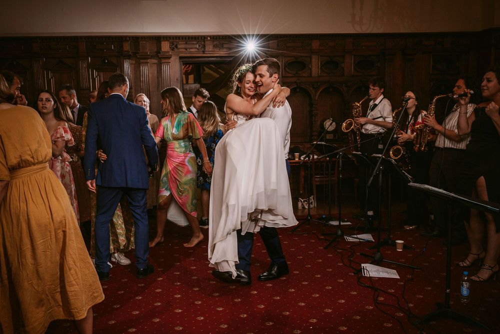 Couple sharing an intimate dance moment at their wedding reception as guests look on.