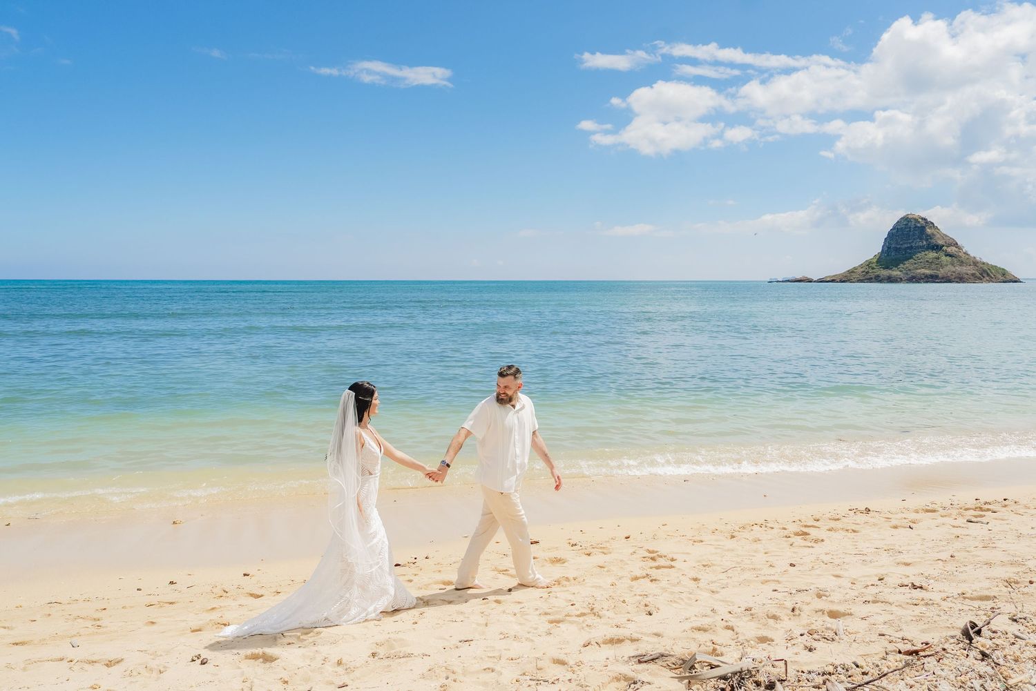 Romantic beach wedding ceremony at Kualoa Ranch, Oahu , Hawaii  pristine white sand beach with turquoise ocean views.