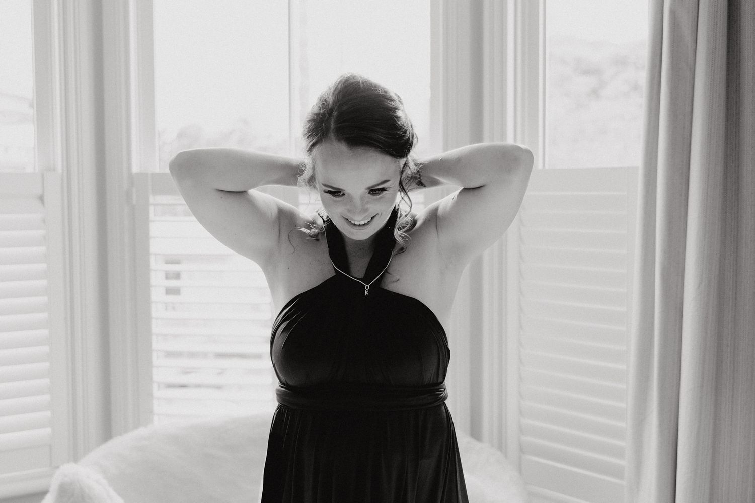 Black and white photo captures joyful moment of a bridesmaid, captured by Apertured Media Auckland Wedding Photographer.