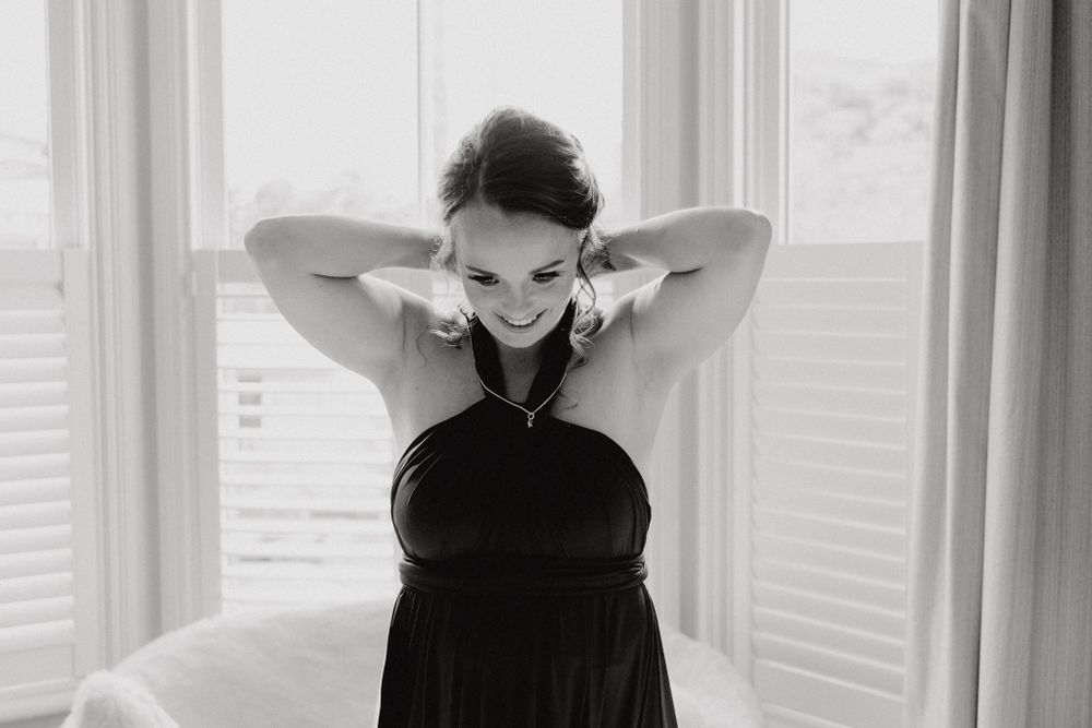 Black and white photo captures joyful moment of a bridesmaid, captured by Apertured Media Auckland Wedding Photographer.