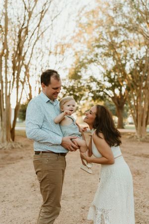 A family shares joyful moments together in a sunlit outdoor setting.