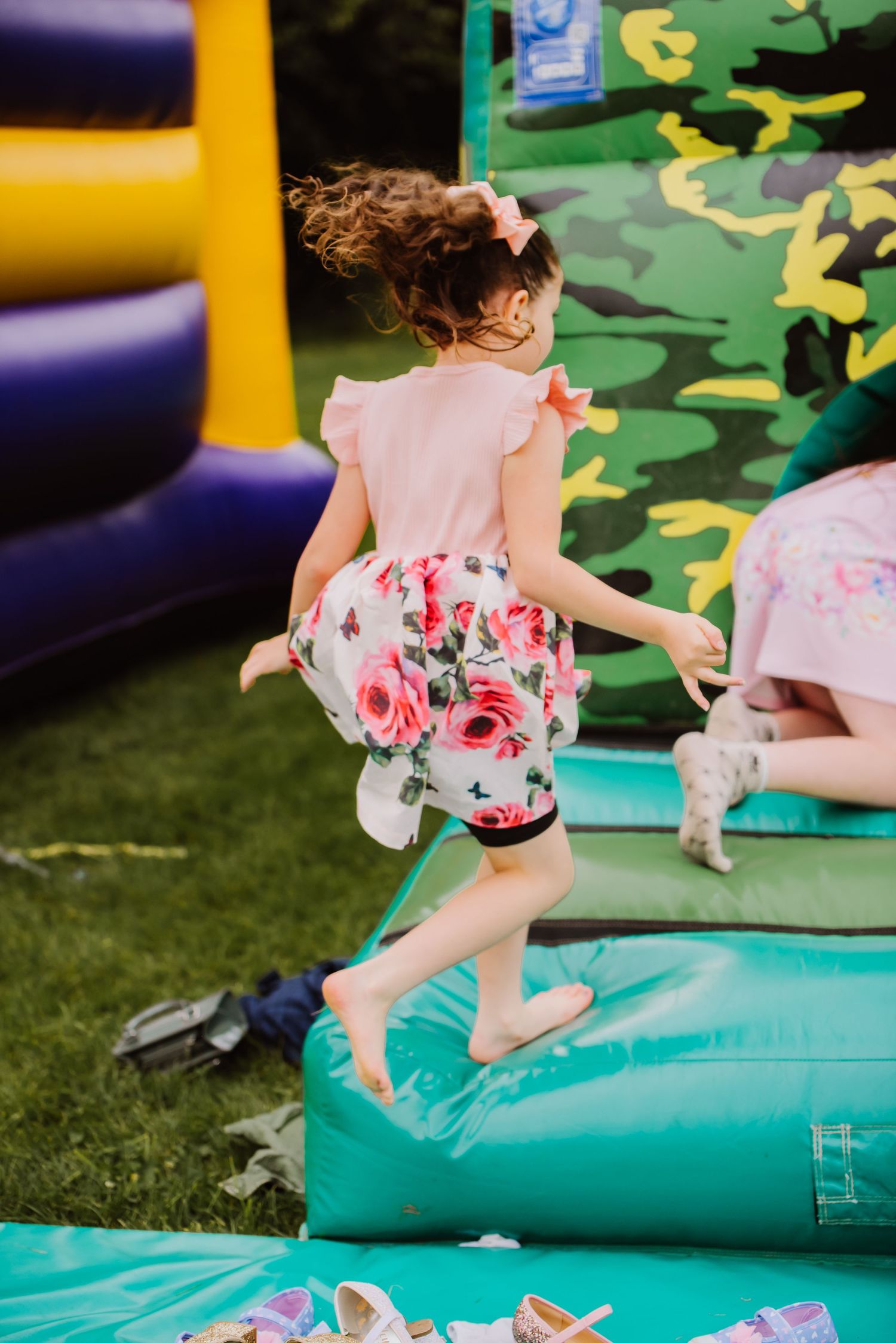 A girl is jumping on to a bouncy castle at a wedding at Dorchester Rugby Club. Dorset. Wedding venue Dorchester. Bouncy Castle Dorchester