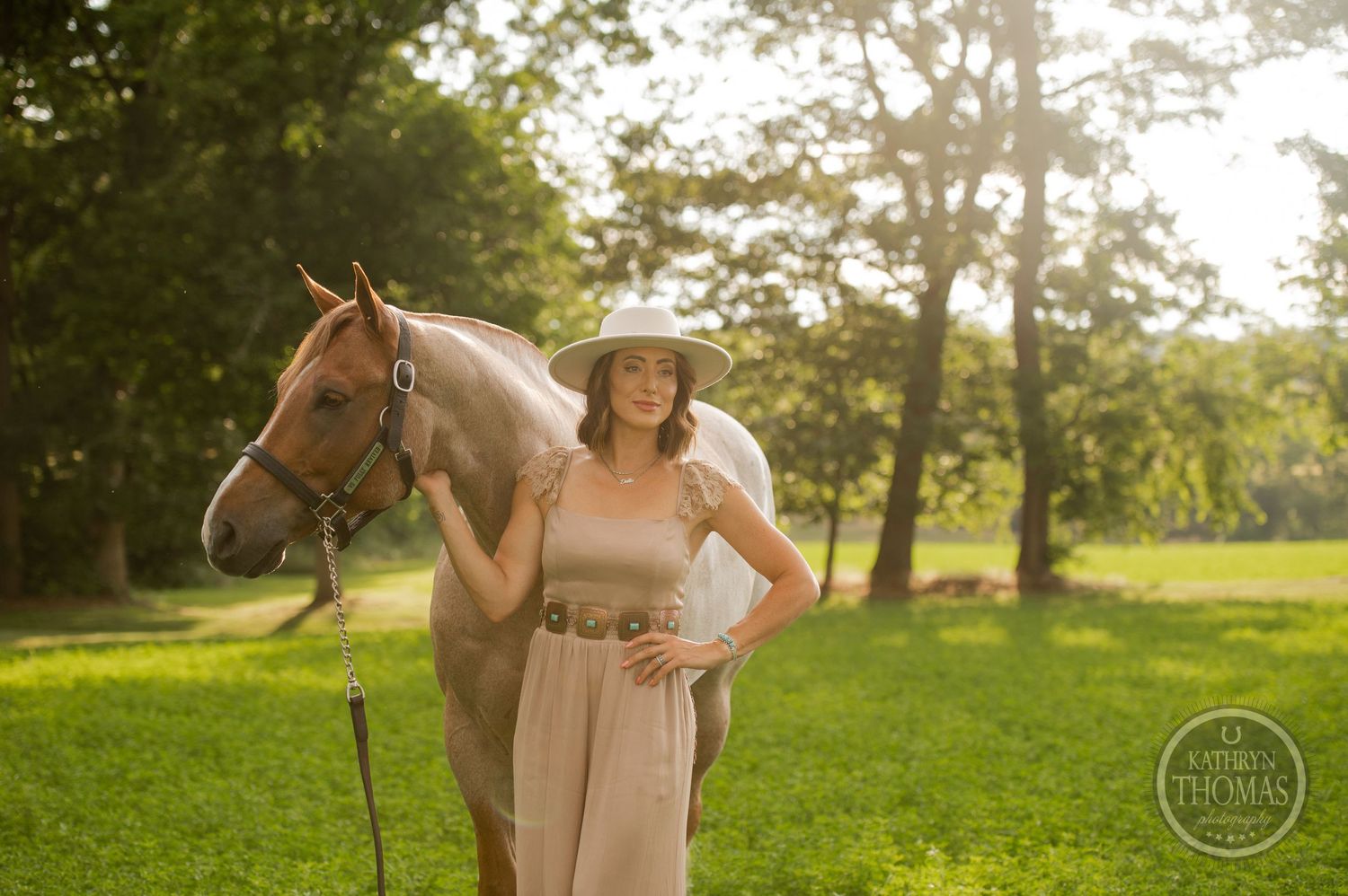 Elegant horse and companion posing in sunlit meadow with western-style attire.
