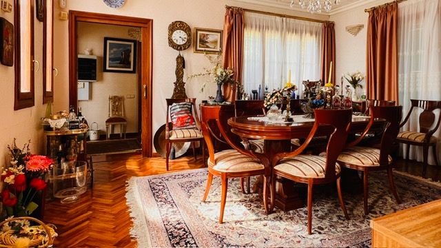 Elegant dining room with antique furniture, grandfather clock, and hardwood flooring.