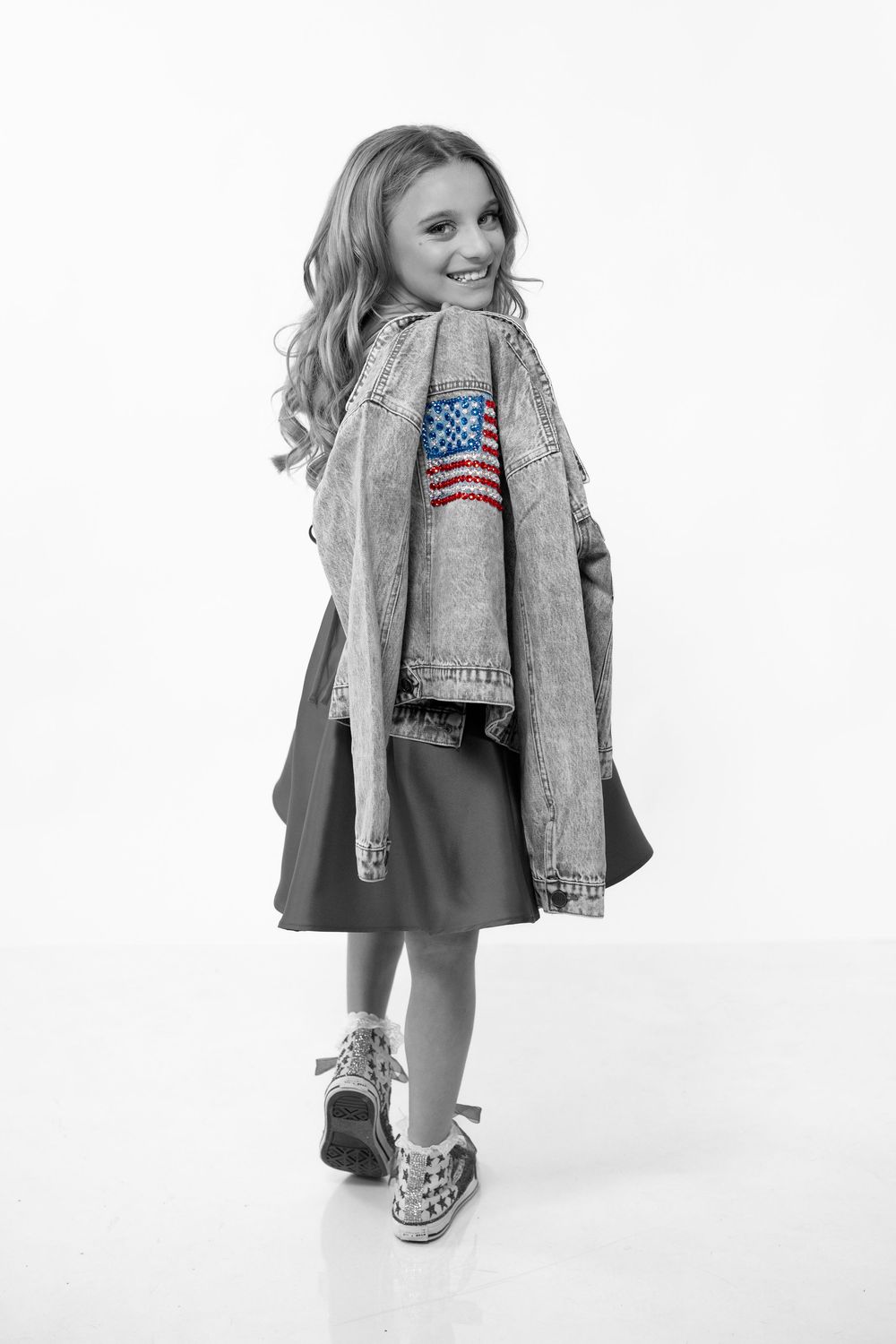 Young model wearing distressed denim jacket and American flag shirt poses in black and white studio portraits.