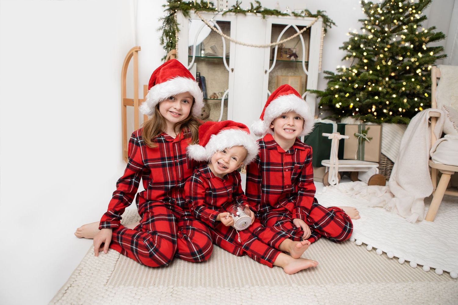 Festive holiday scene with matching red plaid pajamas and Christmas decorations.