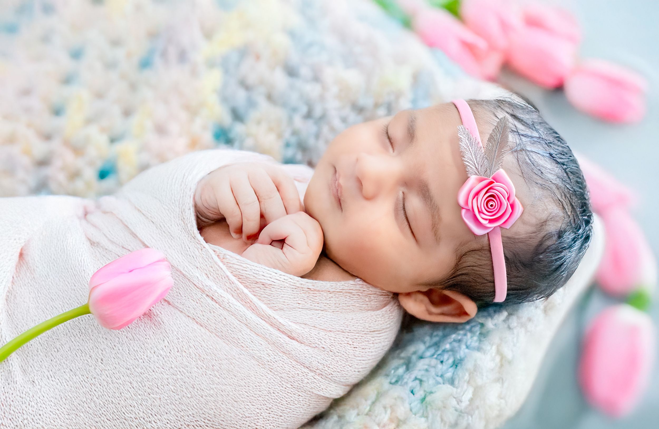 Baby portrait with pink roses and soft blue background.
