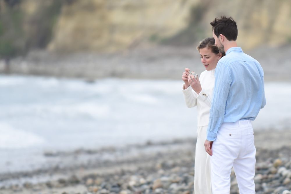 Series of candid moments showing a couple celebrating on a rocky shoreline.