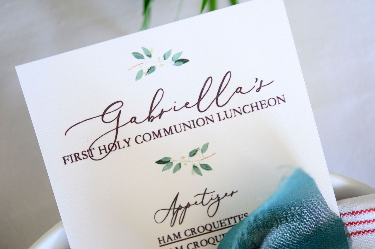 First Holy Communion luncheon invitation card with green watercolor leaf details.
