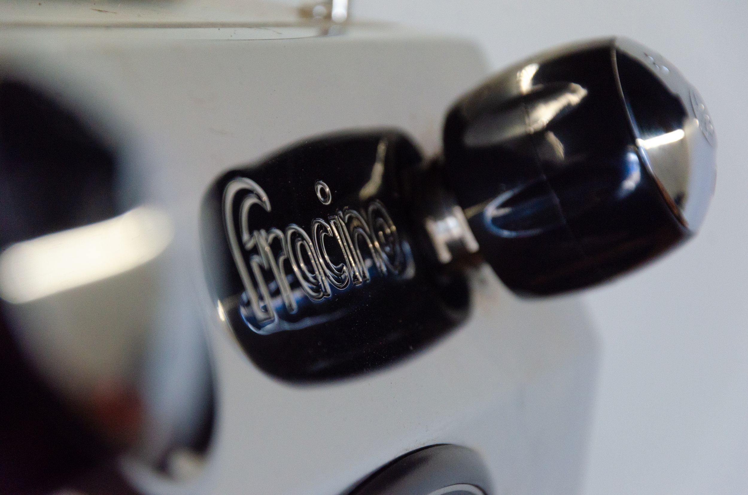 Macro shot of black coffee machine controls in soft focus.