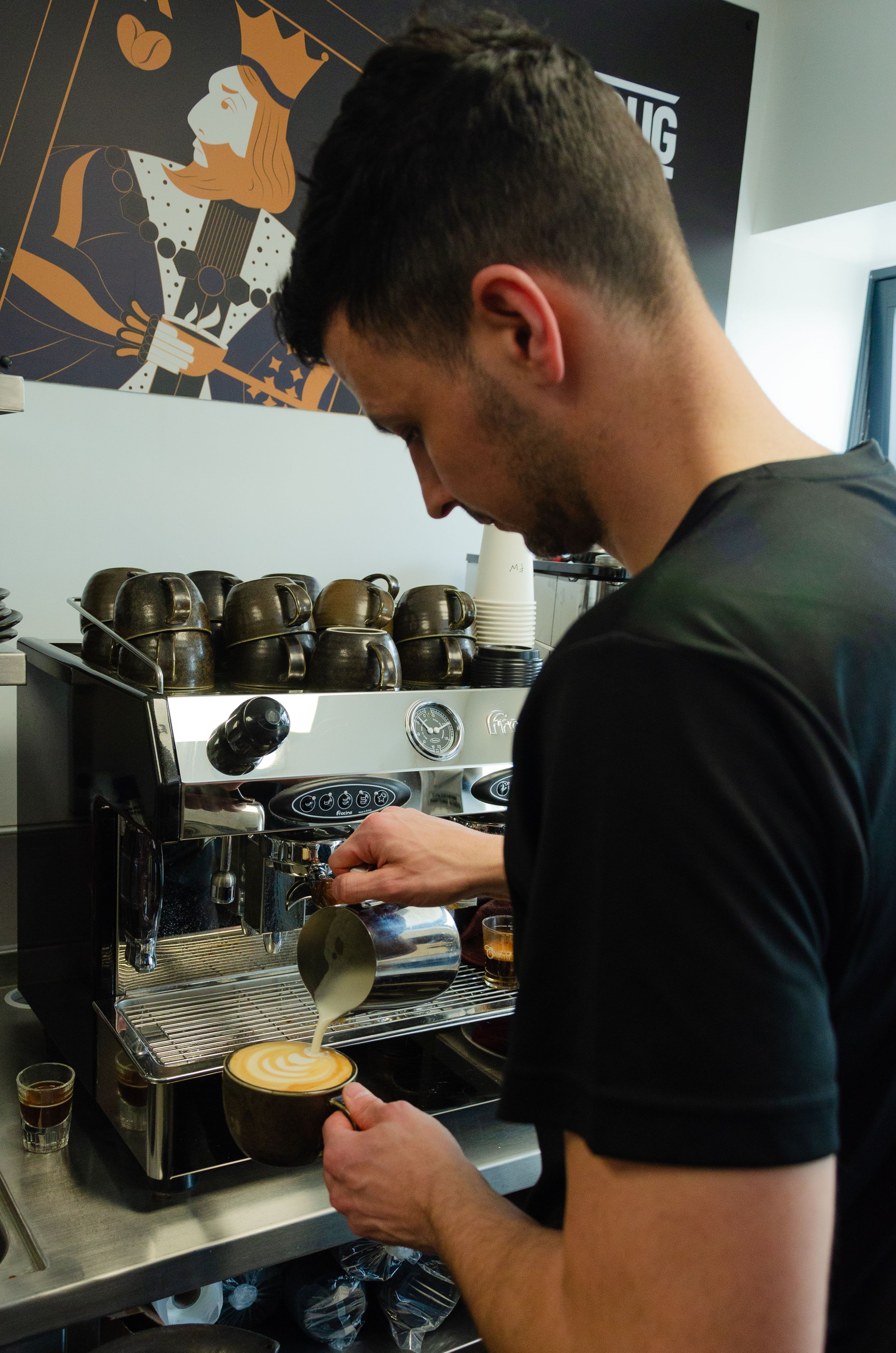 Barista preparing espresso shot on a professional coffee machine.